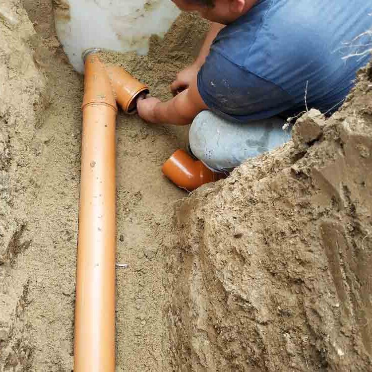 Supply of a sewer pipe to a sump by a master locksmith in the countryside.